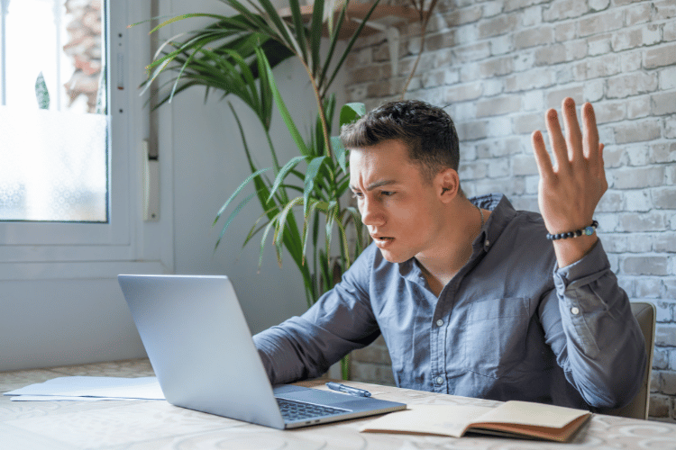 Annoyed young man looking at his laptop